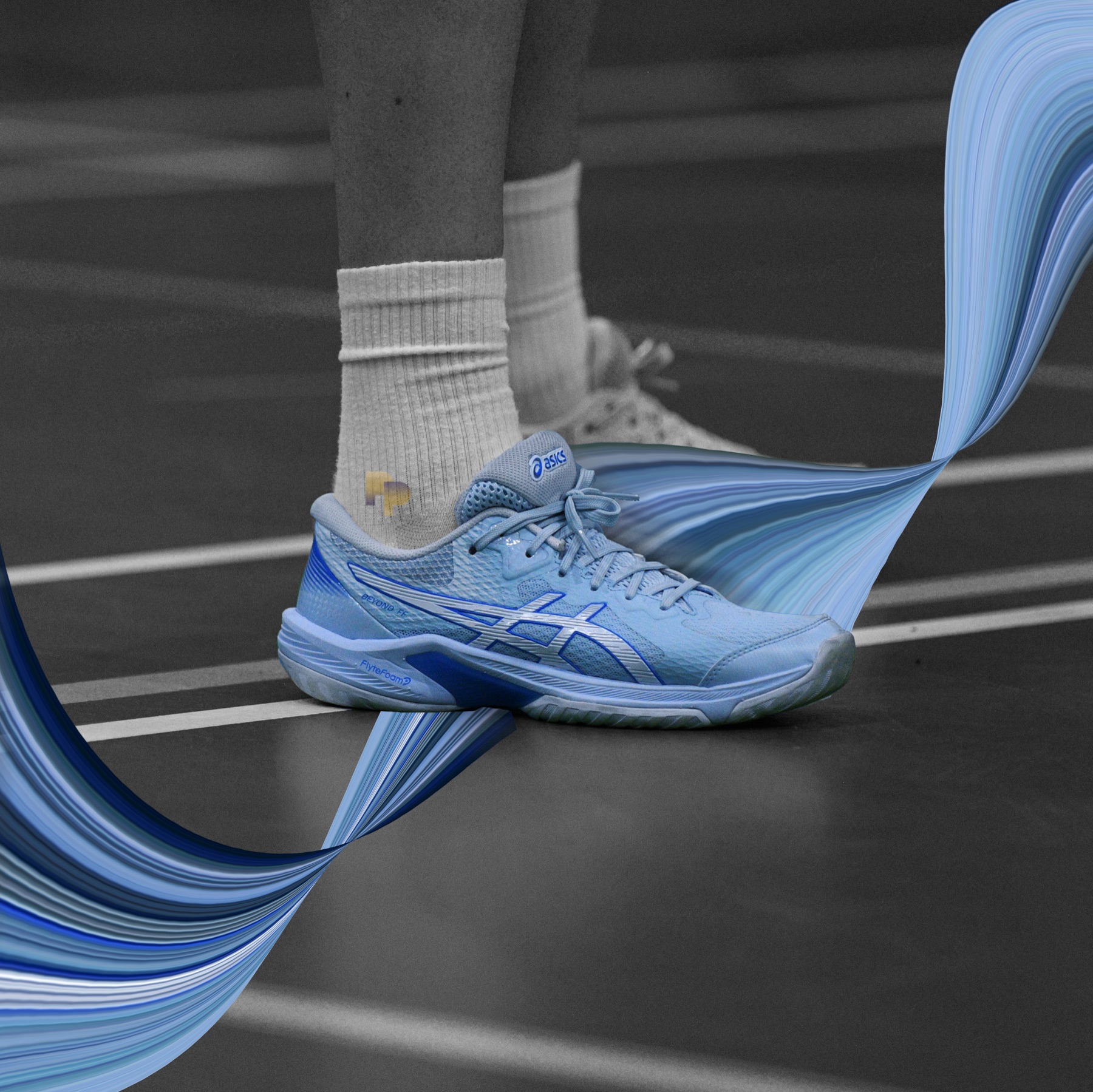 A blue court shoe mid-step, a blue ribbon sweeping through the monochrome frame