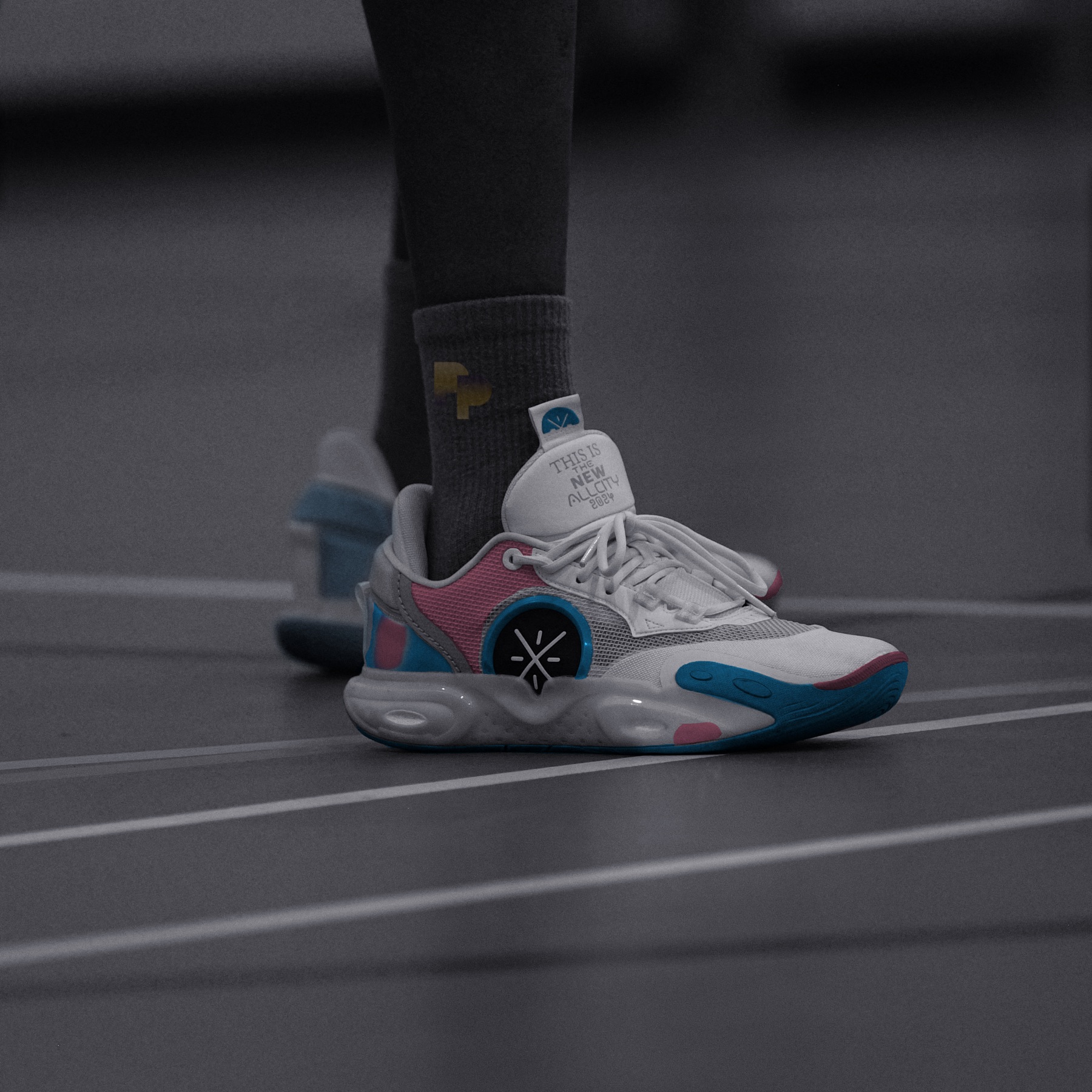 Court shoes in trans pride colours at rest on a dark court